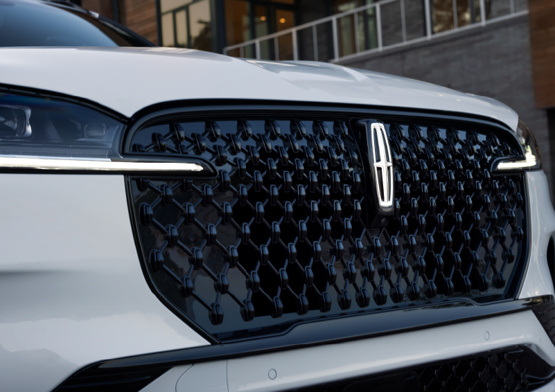 The black grille of a white 2025 Lincoln Aviator® SUV is shown with its fog lights on. | Joe Rizza Lincoln of Orland Park in Orland Park IL