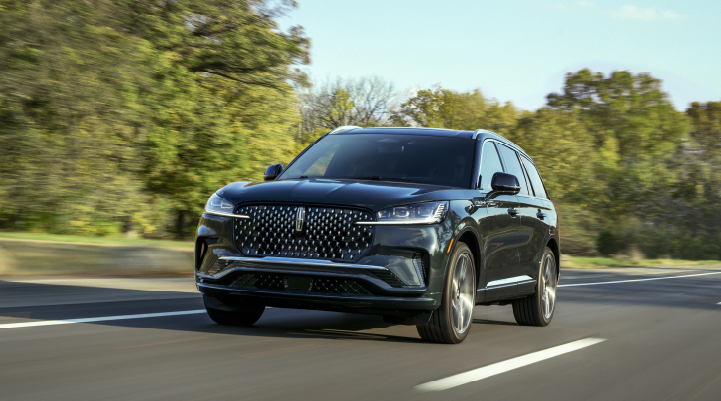 A 2025 Lincoln Black Label Aviator® SUV is being driven down a road lined with trees. | Joe Rizza Lincoln of Orland Park in Orland Park IL