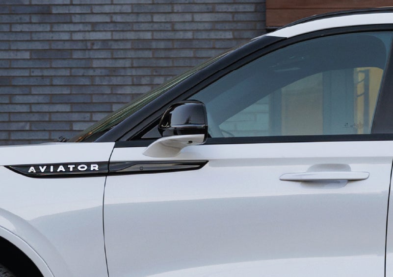 The driver’s side door and fender badging of a white 2026 Lincoln Aviator® SUV are showcased. | Joe Rizza Lincoln of Orland Park in Orland Park IL