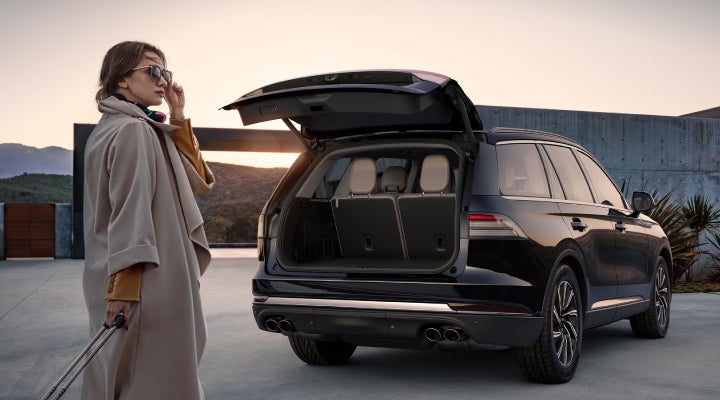 A woman approaches a 2026 Lincoln Aviator® SUV with its rear liftgate open. | Joe Rizza Lincoln of Orland Park in Orland Park IL