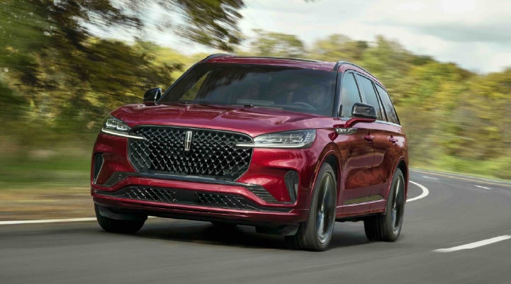A 2027 Lincoln Aviator® SUV is being driven on a country road | Joe Rizza Lincoln of Orland Park in Orland Park IL