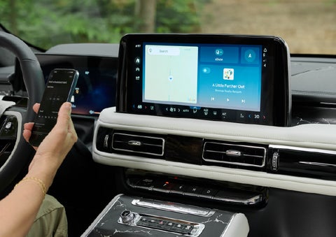 A person pairs thier phone with the center touchscreen of a 2027 Lincoln Aviator® Black Label™ SUV | Joe Rizza Lincoln of Orland Park in Orland Park IL